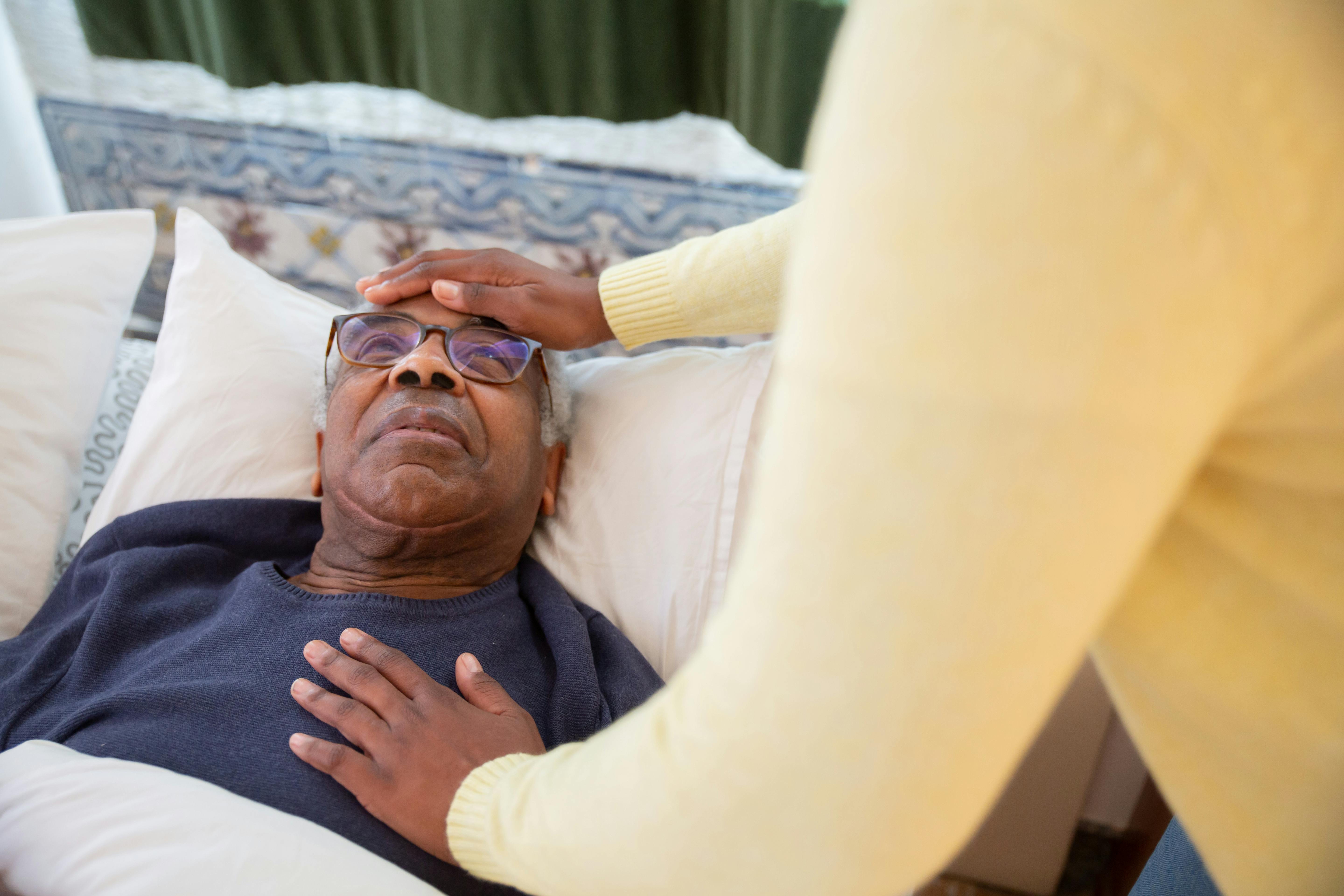 Registered nurse having a compassionate conversation with a senior patient in a home setting