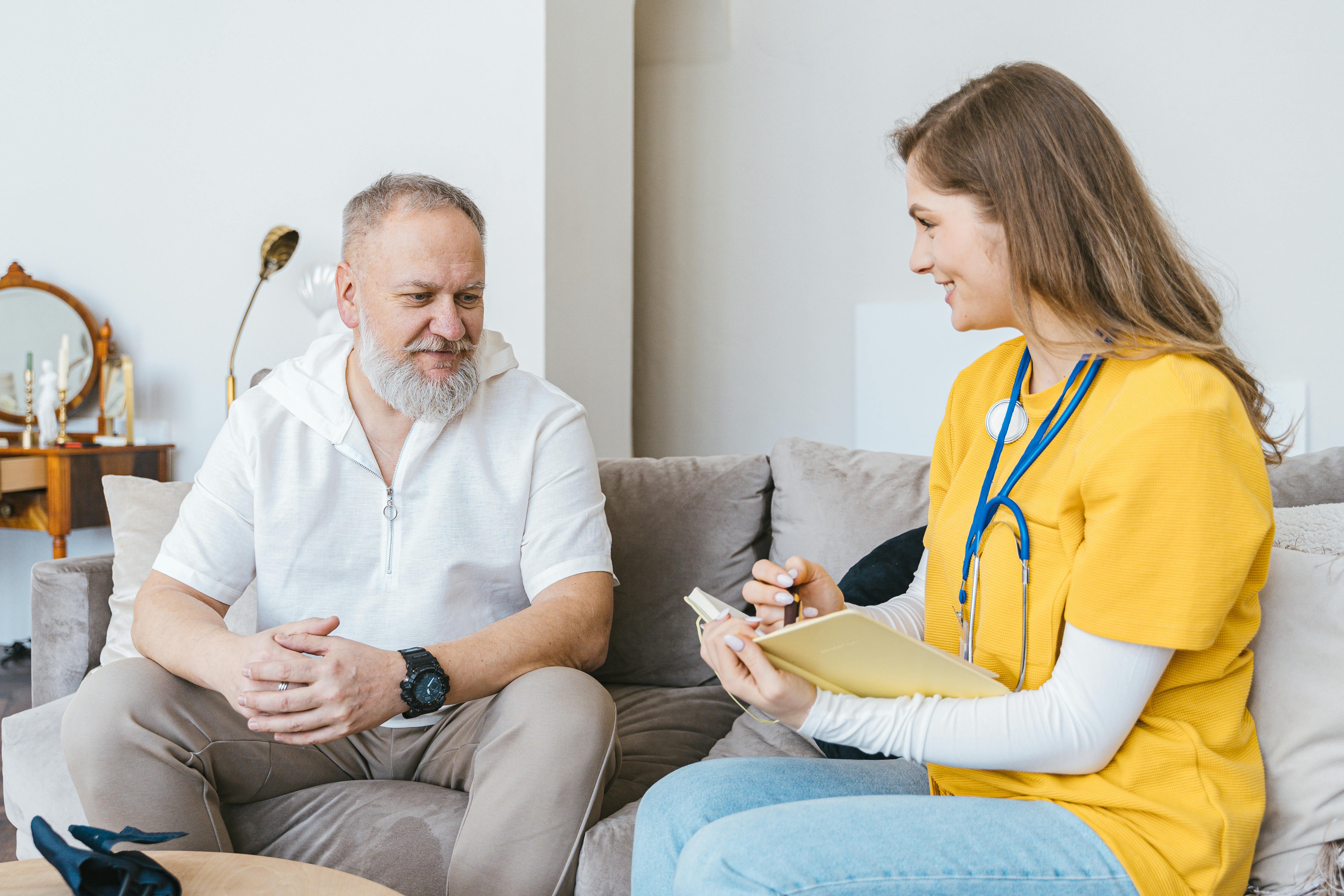 A professional registered nurse assisting a patient at home
