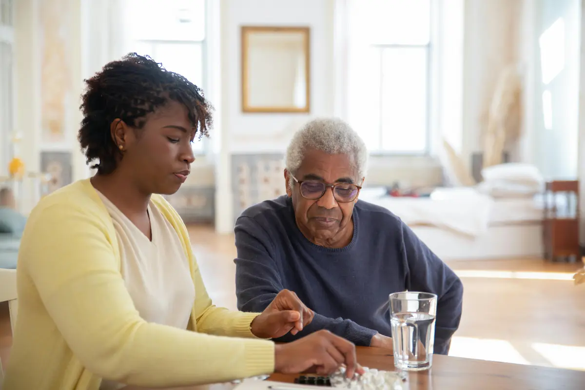 A Family First nurse explaining hydration and UTI prevention steps to an elderly client in their Belleville home.